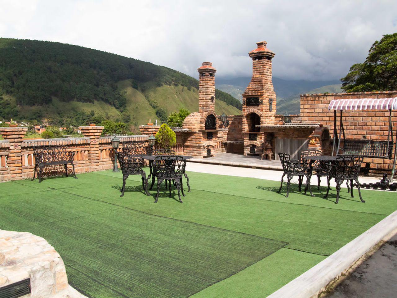Terraza con hornos de leña y chimeneas de ladrillo frente a la montaña